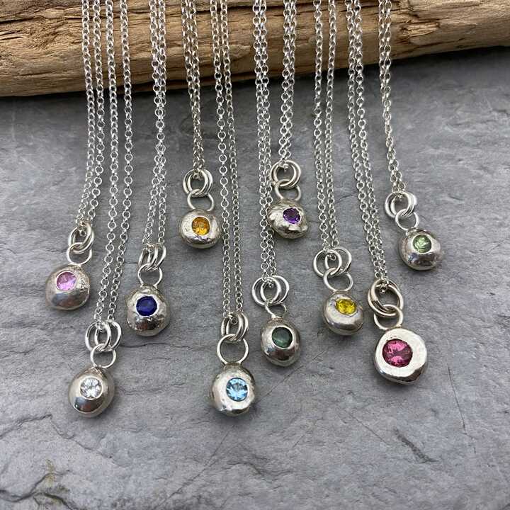 This is a picture of a selection of small silver nuggets set with colourful gemstones