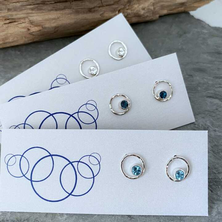 This is an image of silver earrings displayed on a card