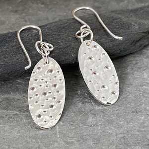 This is an image of a pair of bubbles patterned silver earrings