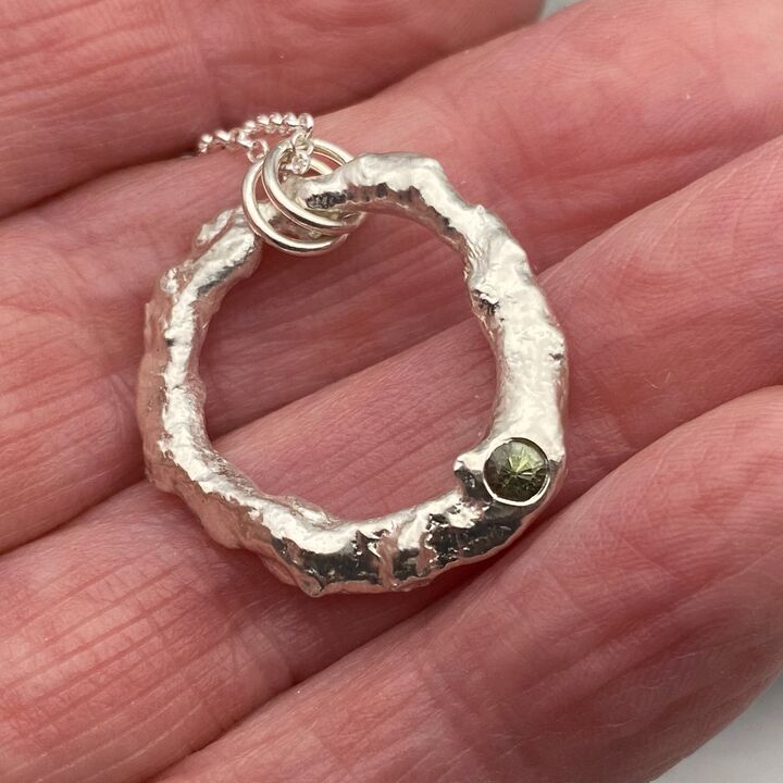 Organic silver circle pendant with a green sapphire  2