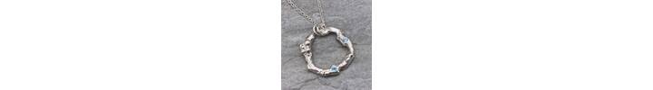 Organic silver circle pendant with two blue Topaz stones. 2