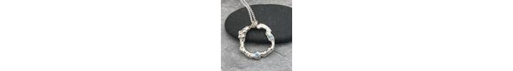 Organic silver circle pendant with two blue Topaz stones.