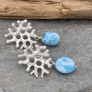 This is a picture of a pair of silver coral shaped earrings with Larimar gemstones